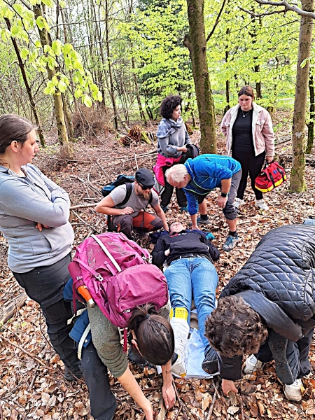 Eine Gruppe, die einem verletzten Wanderer hilft.